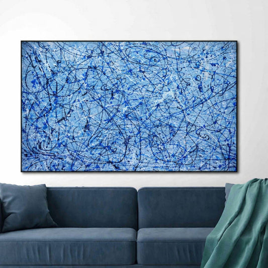 Abstract blue painting on a wall above a blue sofa