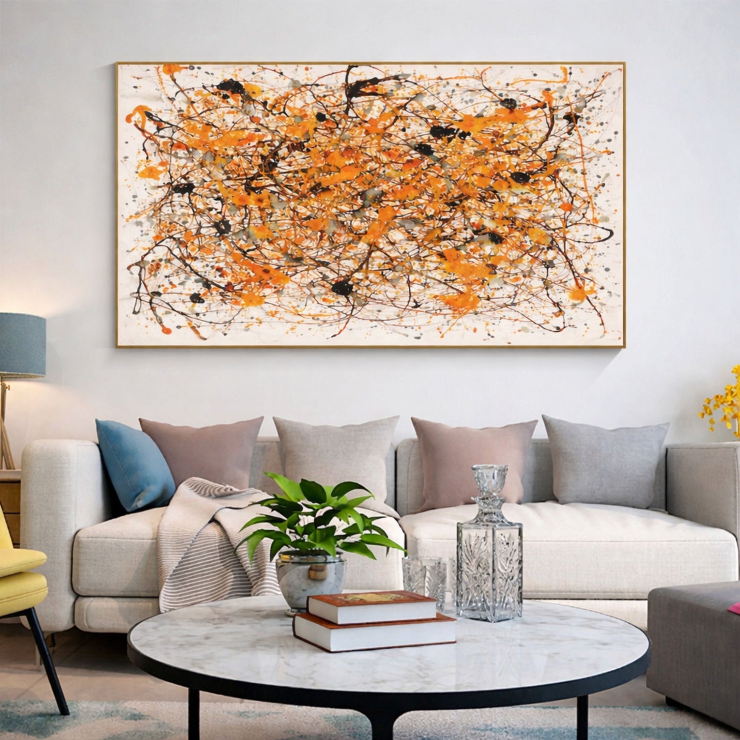 Orange abstract drip artwork with black splatter displayed above neutral sectional sofa