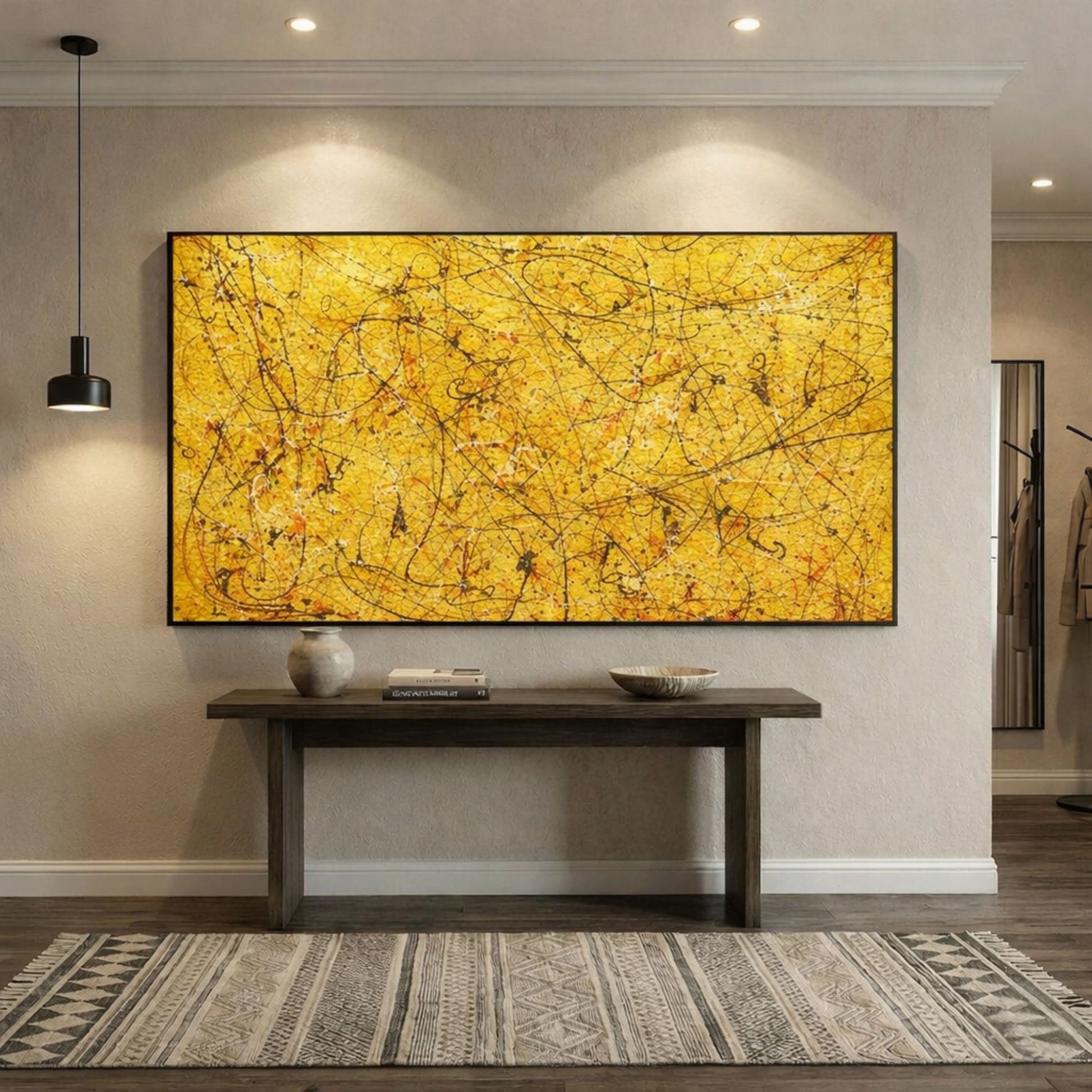 Large yellow abstract drip painting with black lines displayed above wooden console table in modern hallway