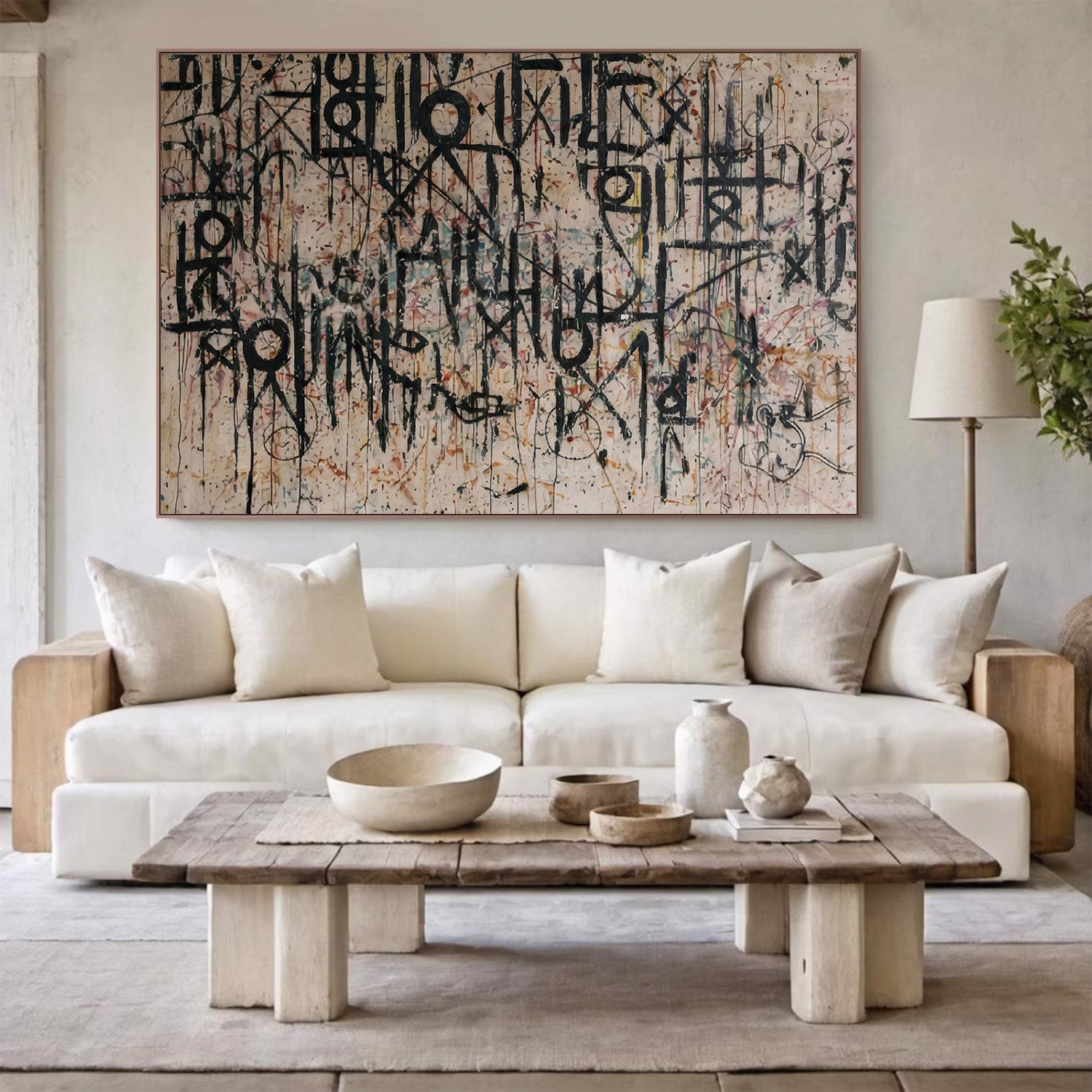 Modern living room with a white sofa, wooden coffee table, and abstract art on the wall.