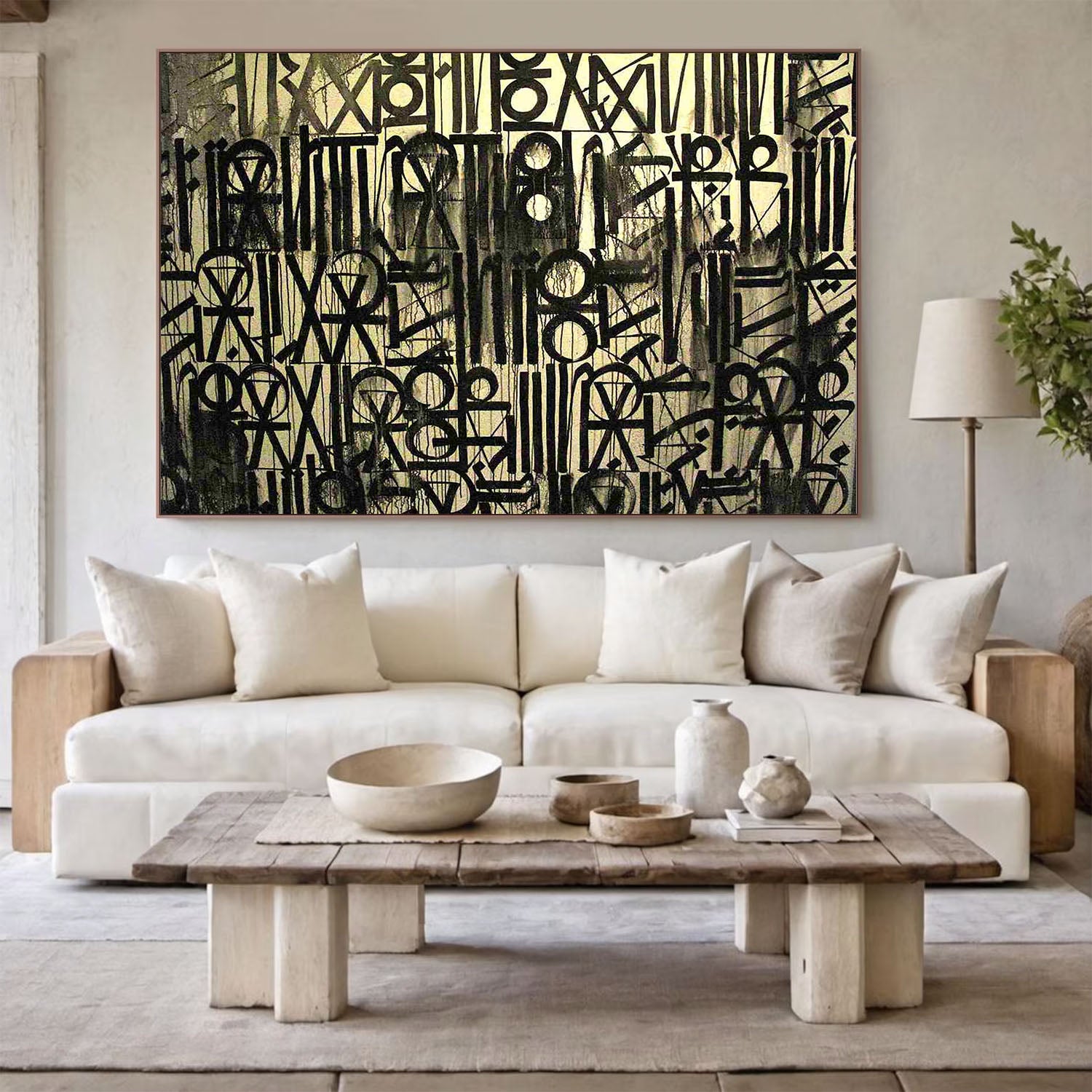 Modern living room with a white sofa, wooden coffee table, and abstract art on the wall.