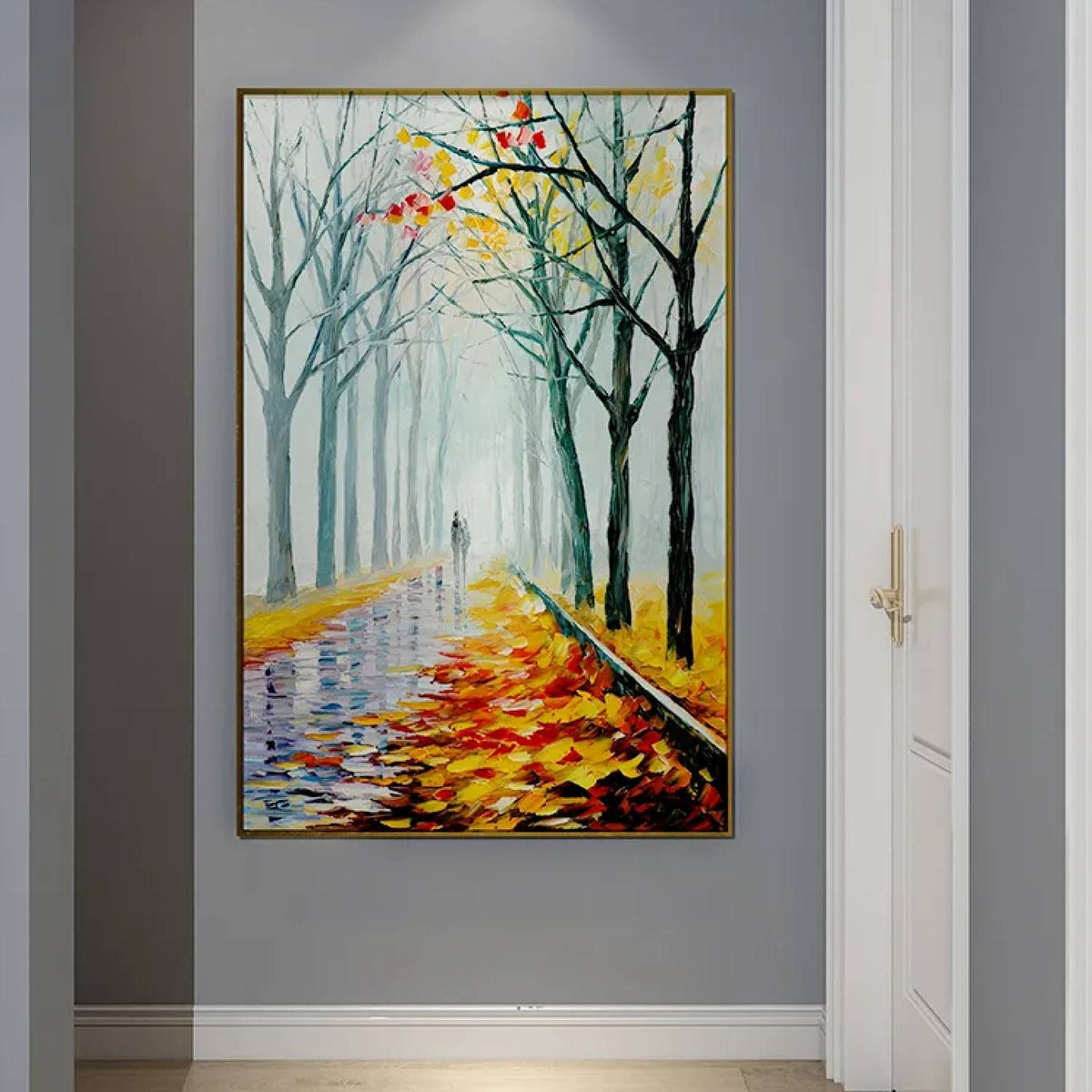Room mockup. A path recedes between bare dark trees, with orange and yellow fallen leaves and a pale misty blue-green distance.