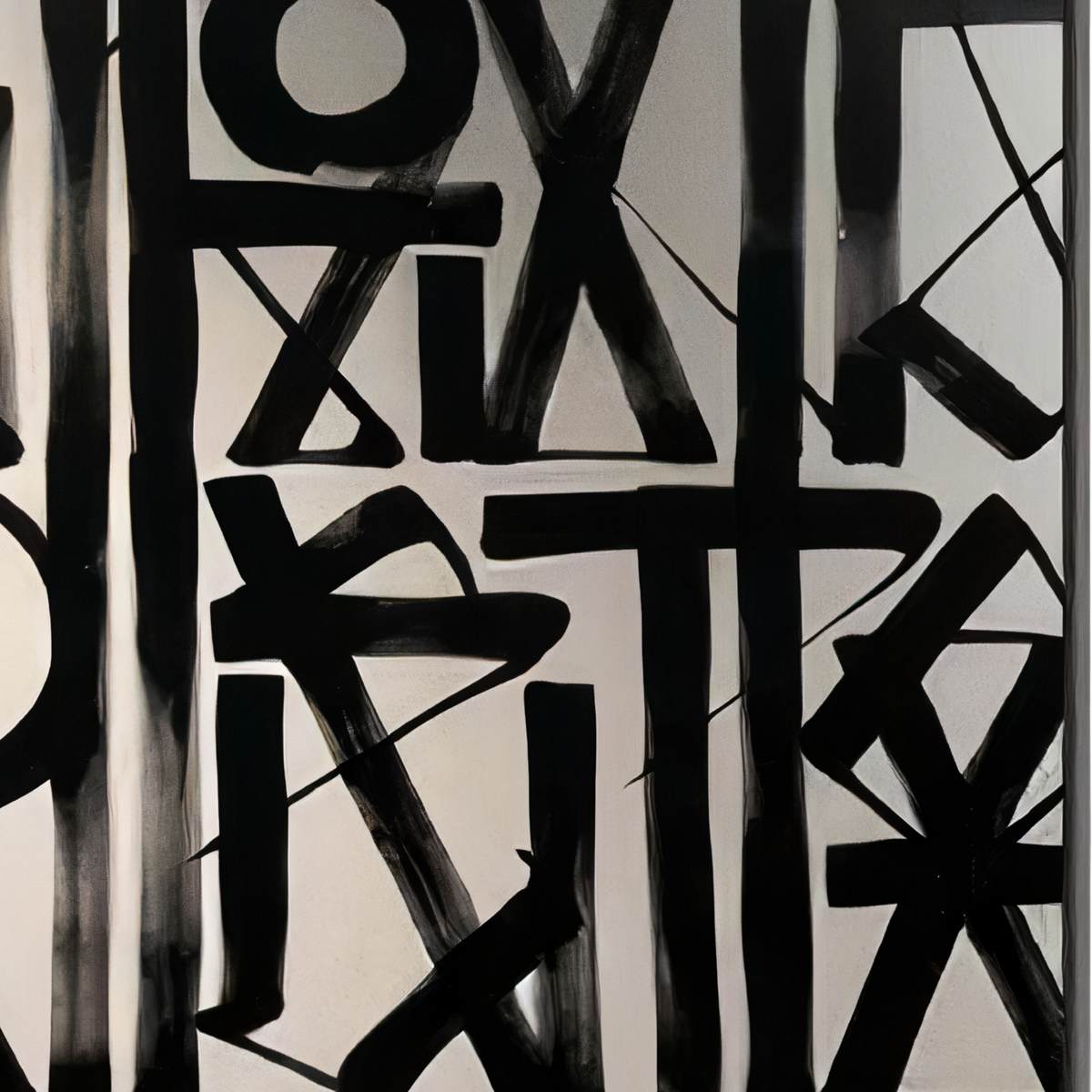 Close-up. Close view of bold black angular marks and curved strokes against a cream background.