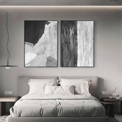 Room mockup showing pair of monochrome abstracts, one with a broad curved white area beneath black and one with vertical grey-white streaks.