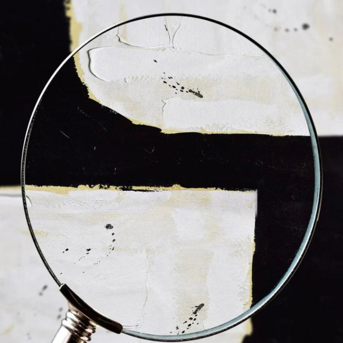 Close-up. A broad black angular shape separates two irregular white blocks, with fine gold-coloured edges and visible texture.
