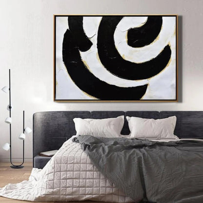 Room mockup. Broad black and white curved bands with fine gold-coloured edges forming an off-centre swirling composition.