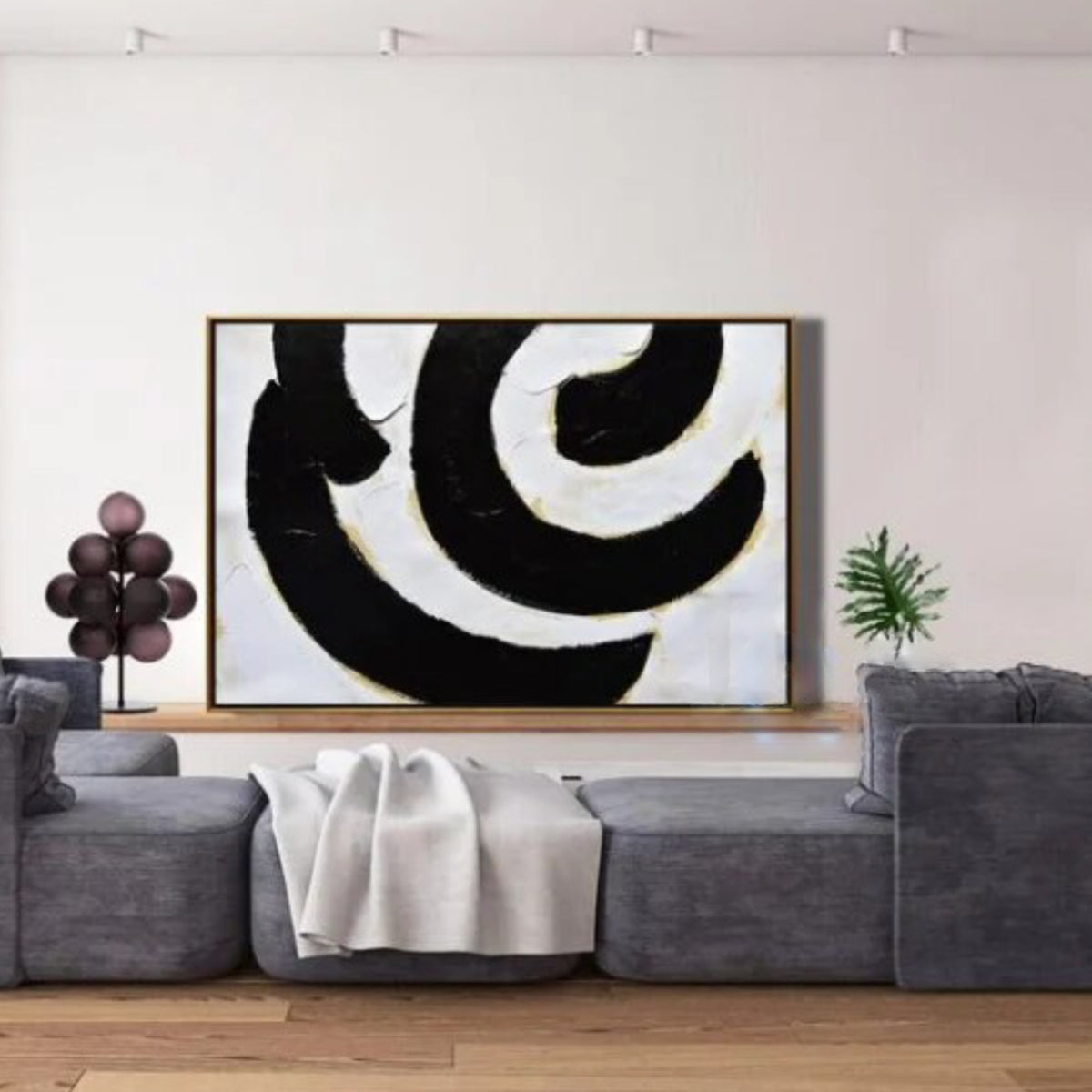 Room mockup. Broad black and white curved bands with fine gold-coloured edges forming an off-centre swirling composition.