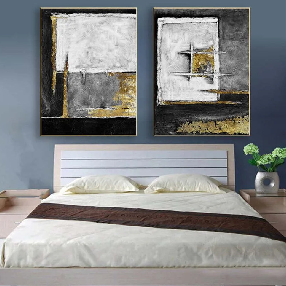 Room mockup showing two textured abstract panels with black, white and grey geometric fields and gold-coloured accents.