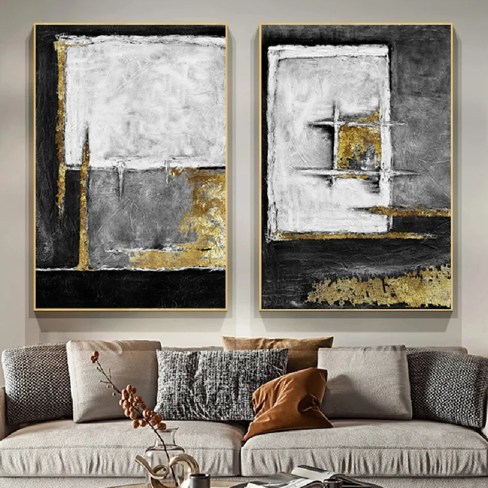 Room mockup showing two textured abstract panels with black, white and grey geometric fields and gold-coloured accents.