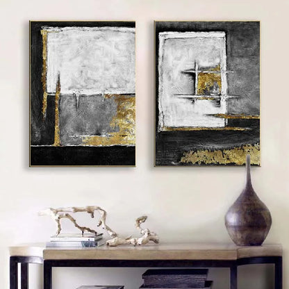 Room mockup showing two textured abstract panels with black, white and grey geometric fields and gold-coloured accents.