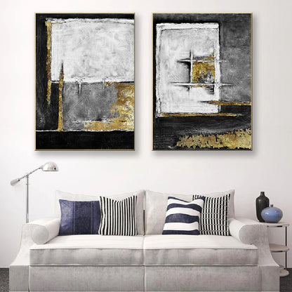 Room mockup showing two textured abstract panels with black, white and grey geometric fields and gold-coloured accents.