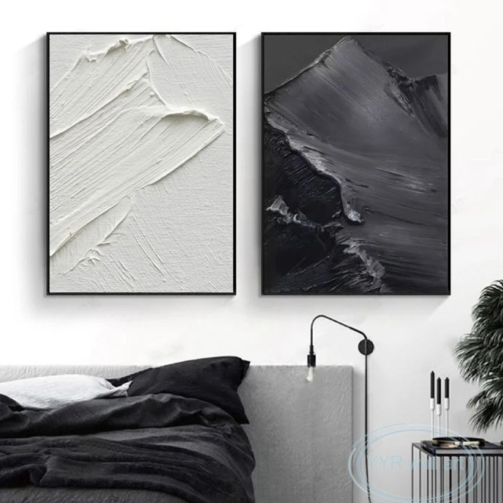 Room mockup showing two monochrome panels with broad raised sweeping brush marks, one white and one charcoal grey.
