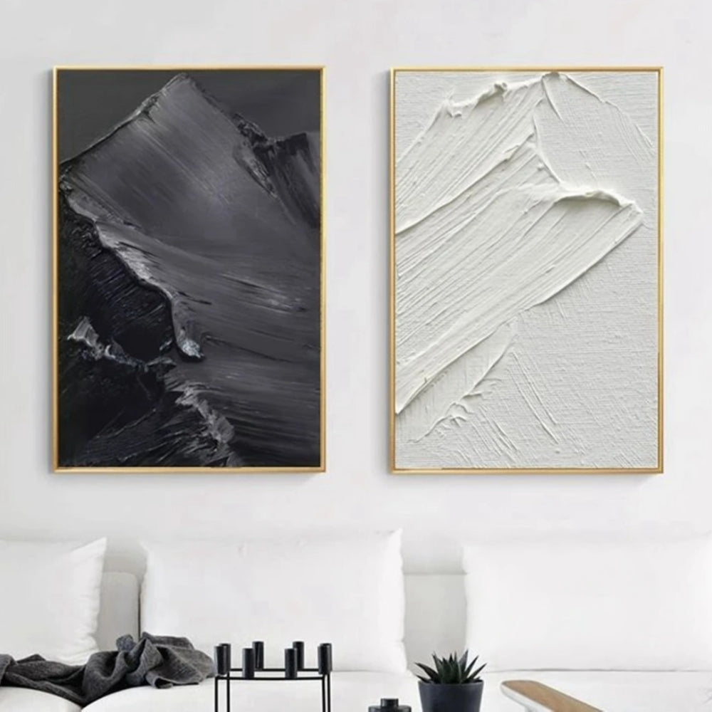 Room mockup showing two monochrome panels with broad raised sweeping brush marks, one white and one charcoal grey.