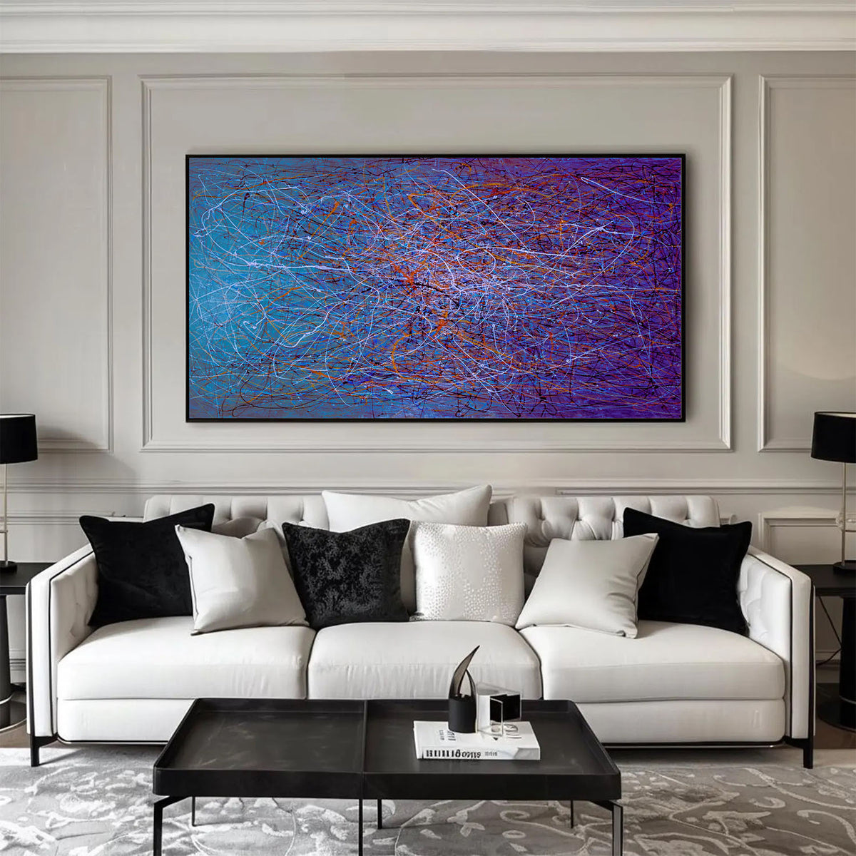 Horizontal abstract painting with purple and blue tones hanging above a white sofa in a modern interior.