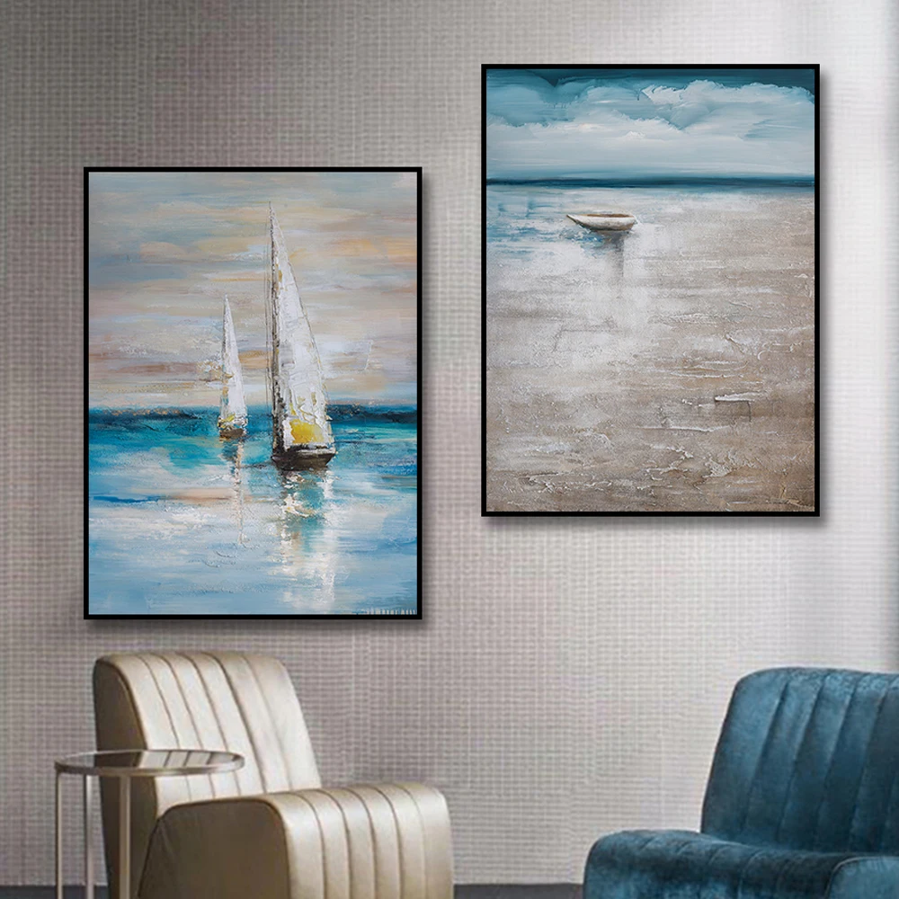 Room mockup showing pair of muted blue and grey seascapes, one with a small boat beneath clouds and one with white-sailed boats.