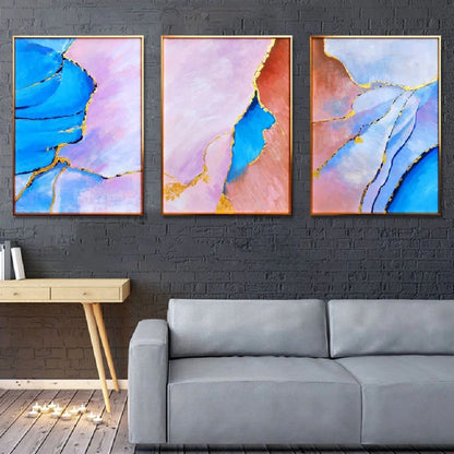 Room mockup showing three abstract panels with vivid blue, pale pink and coral flowing fields divided by thin gold-coloured lines.