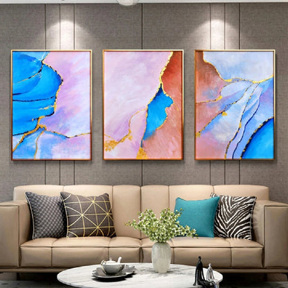 Room mockup showing three abstract panels with vivid blue, pale pink and coral flowing fields divided by thin gold-coloured lines.