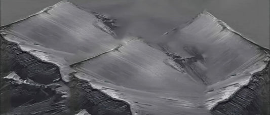 Close-up of charcoal grey textured abstract with broad sweeping raised strokes over deep black areas.