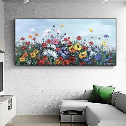 Room mockup showing dense red, yellow, white and purple meadow flowers on green stems beneath a pale blue sky.