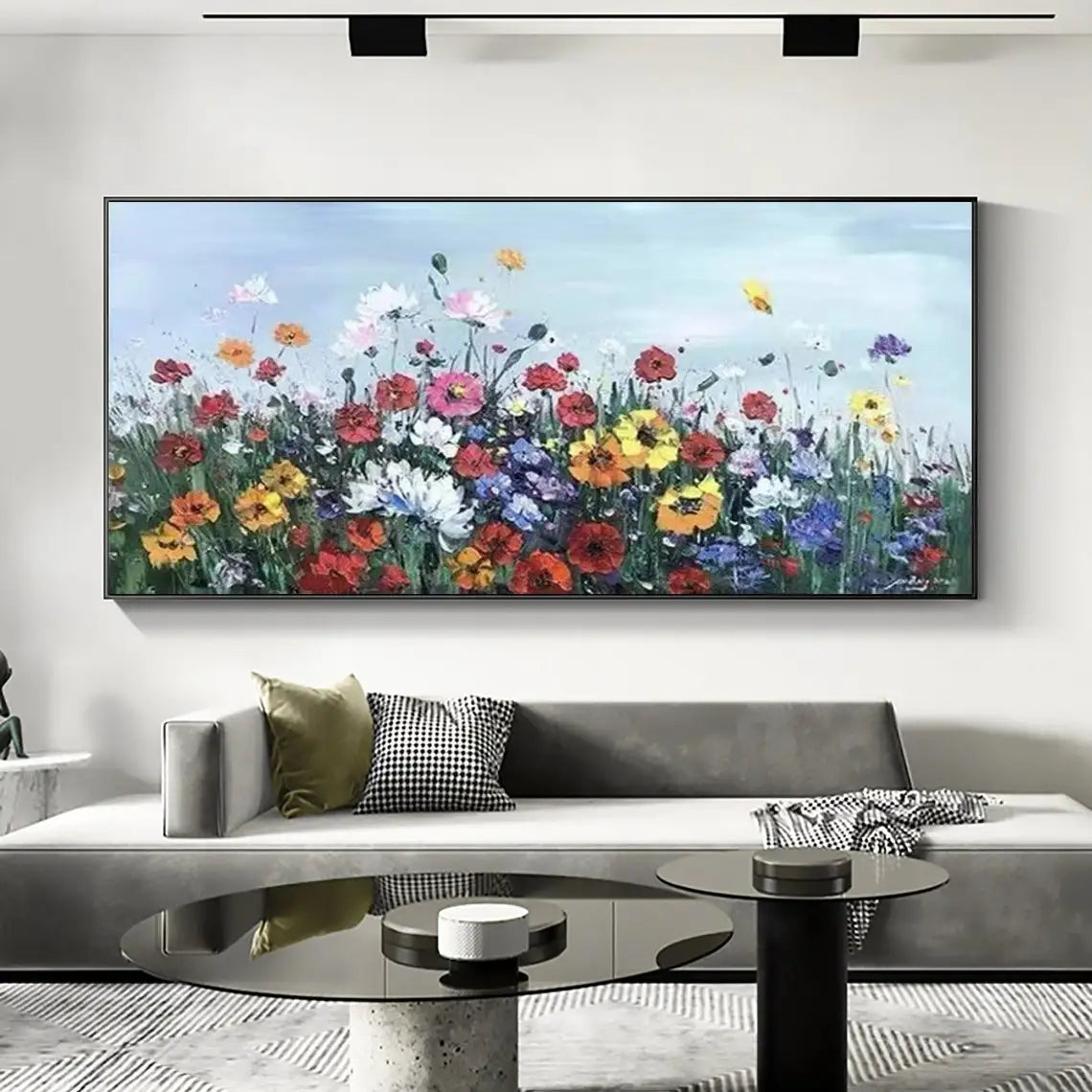 Room mockup showing dense red, yellow, white and purple meadow flowers on green stems beneath a pale blue sky.