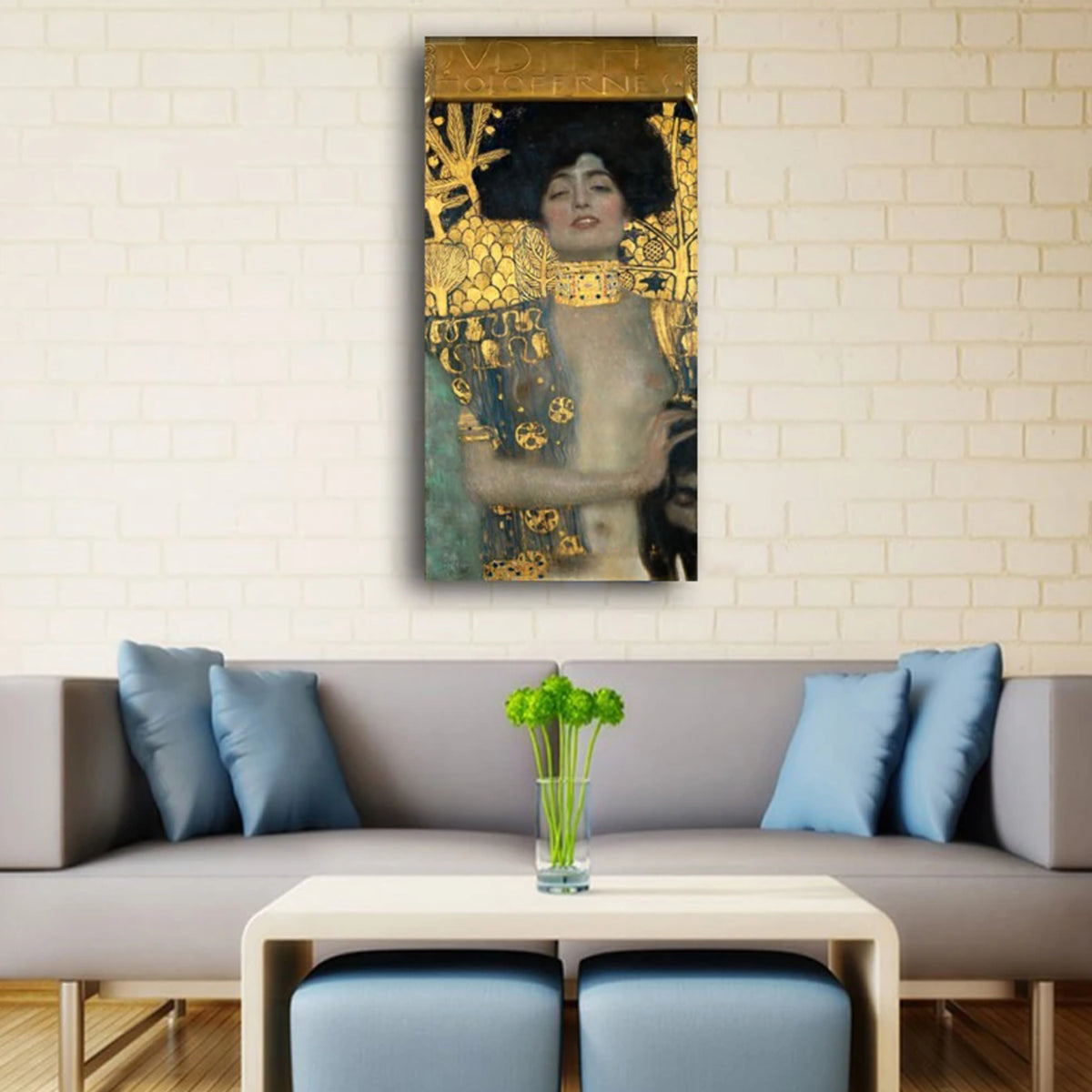 Gold-patterned woman portrait above a grey sofa with blue cushions and a white coffee table.