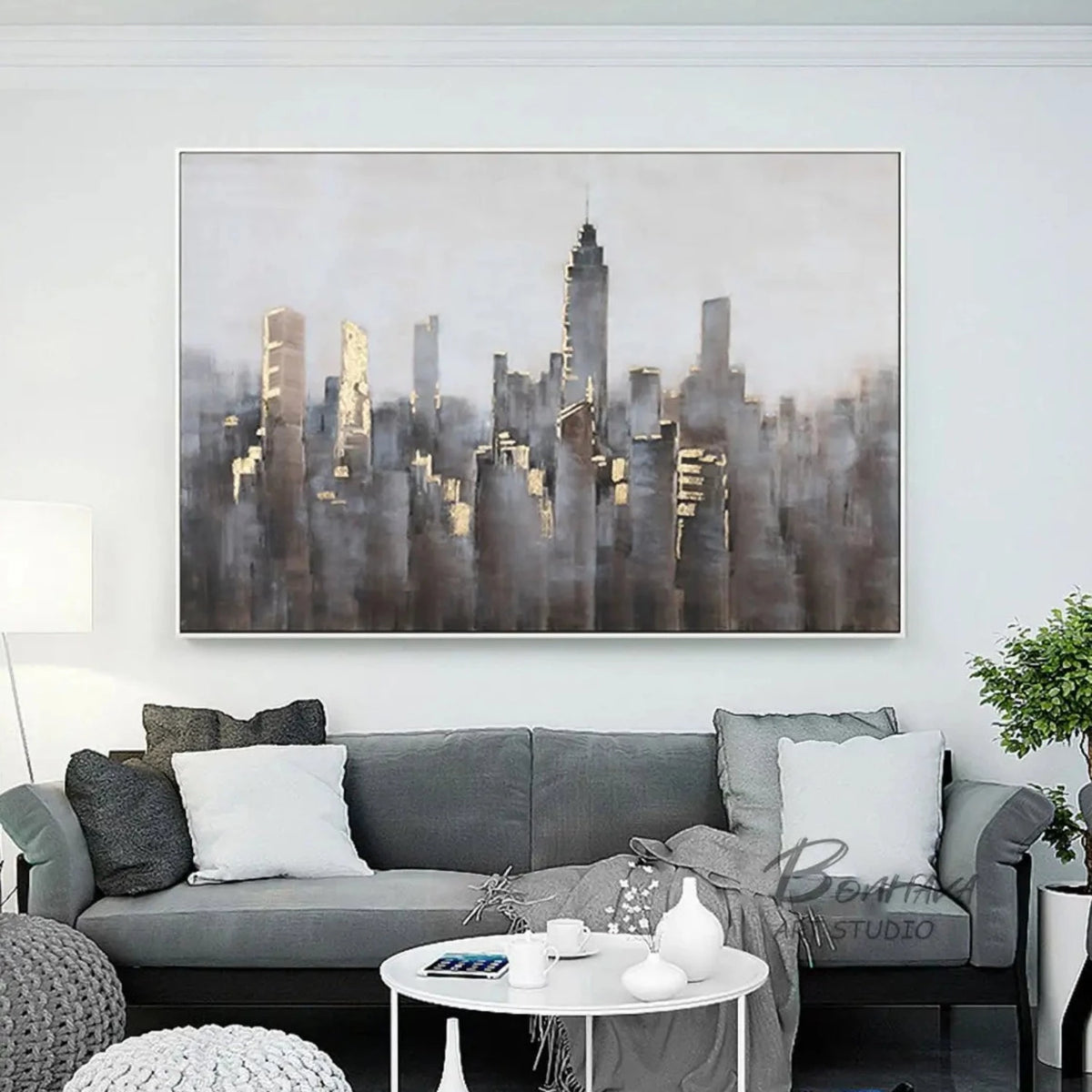 Room mockup showing dense grey and muted brown city towers with small gold-coloured highlights beneath a broad pale grey sky.