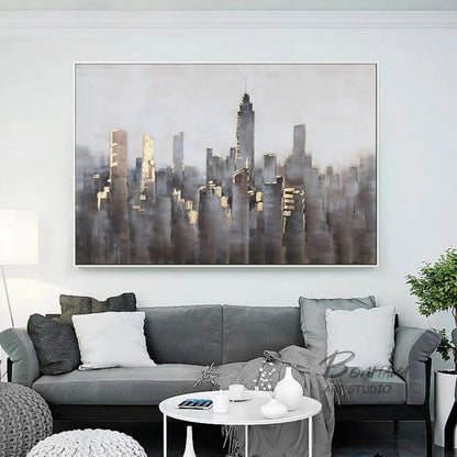 Room mockup showing dense grey and muted brown city towers with small gold-coloured highlights beneath a broad pale grey sky.