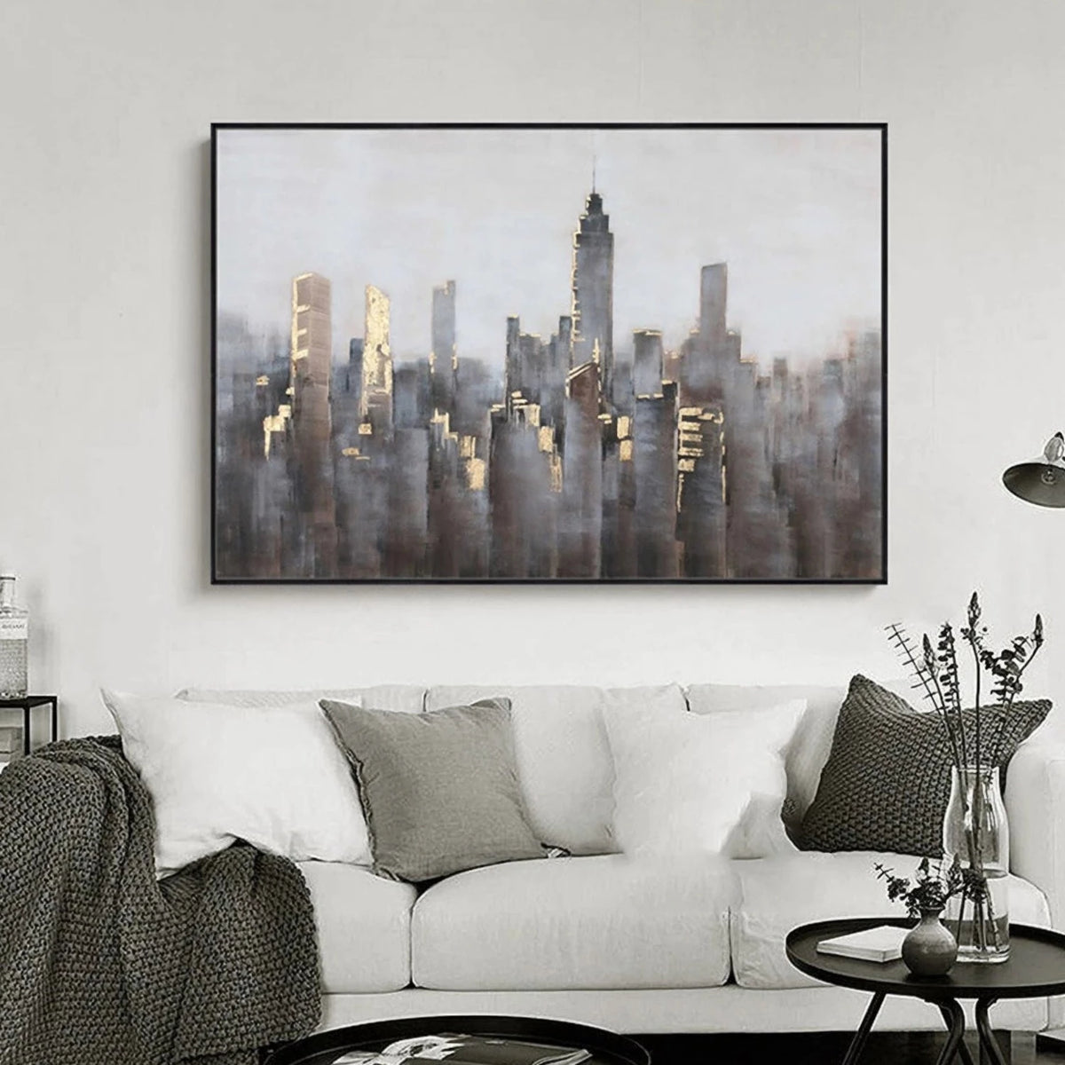 Room mockup showing dense grey and muted brown city towers with small gold-coloured highlights beneath a broad pale grey sky.