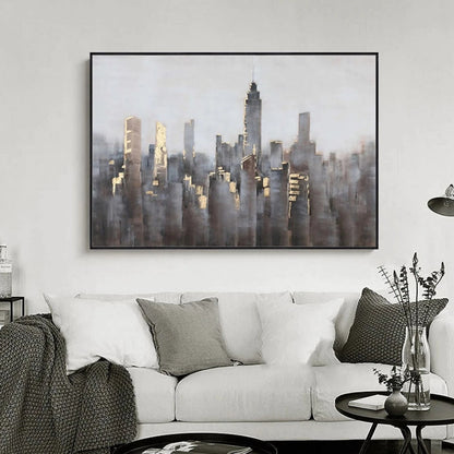 Room mockup showing dense grey and muted brown city towers with small gold-coloured highlights beneath a broad pale grey sky.