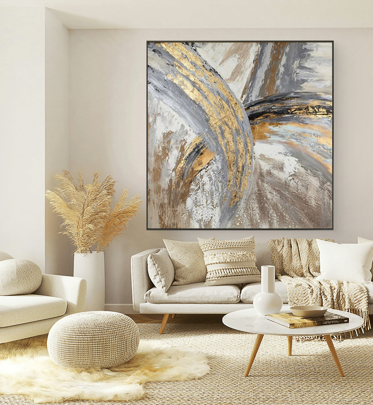 A gold and grey abstract painting displayed on a wall above a modern living room setup with neutral colored furniture and decorative items.