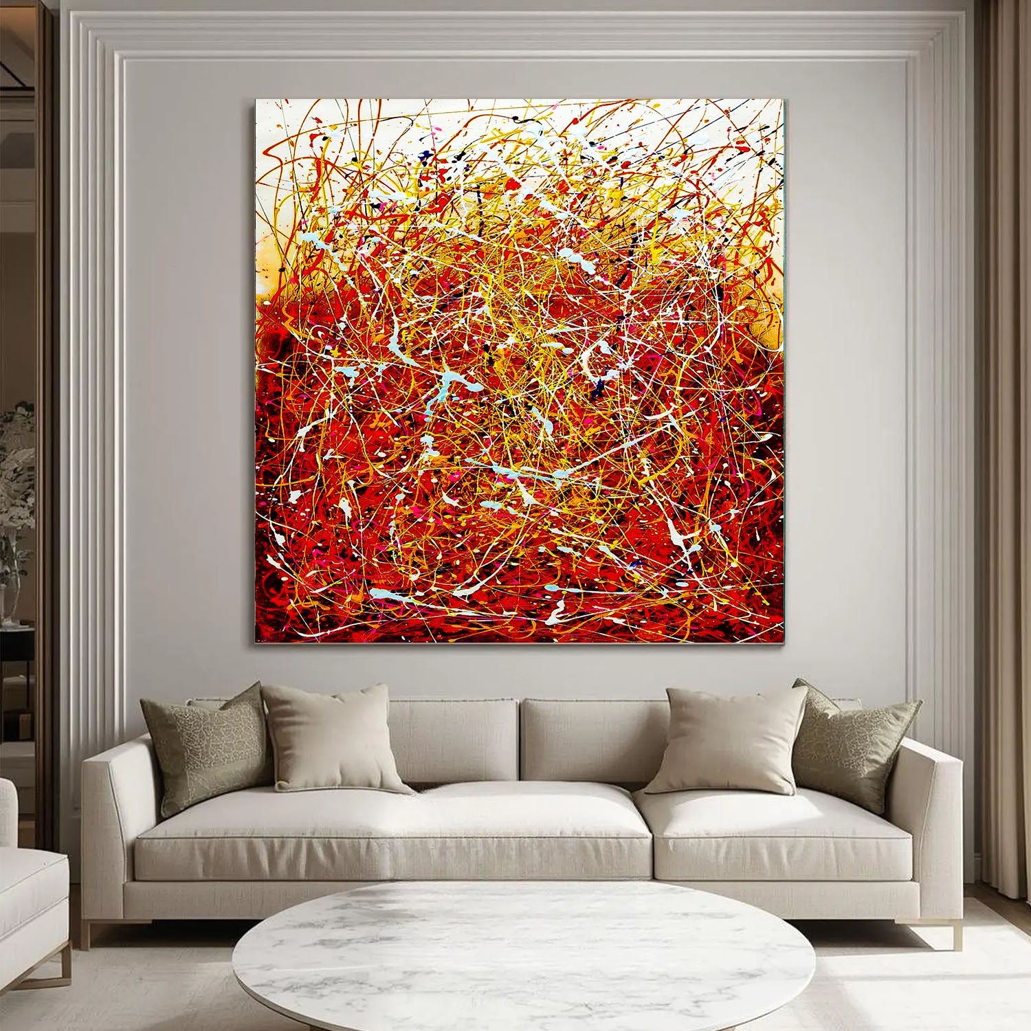 Abstract painting in a modern living room with a beige sofa and round coffee table.