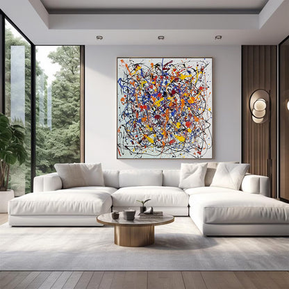 Large abstract expressionist artwork hanging above a white sectional sofa in a bright modern living room with floor-to-ceiling windows.