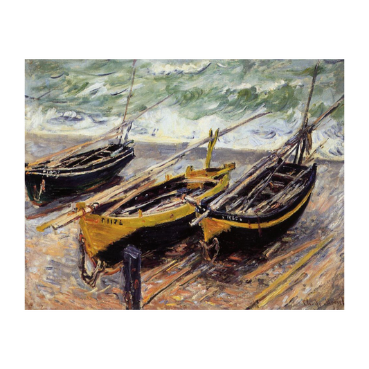 Yellow and black fishing boats resting on a sloping beach beside rough sea.