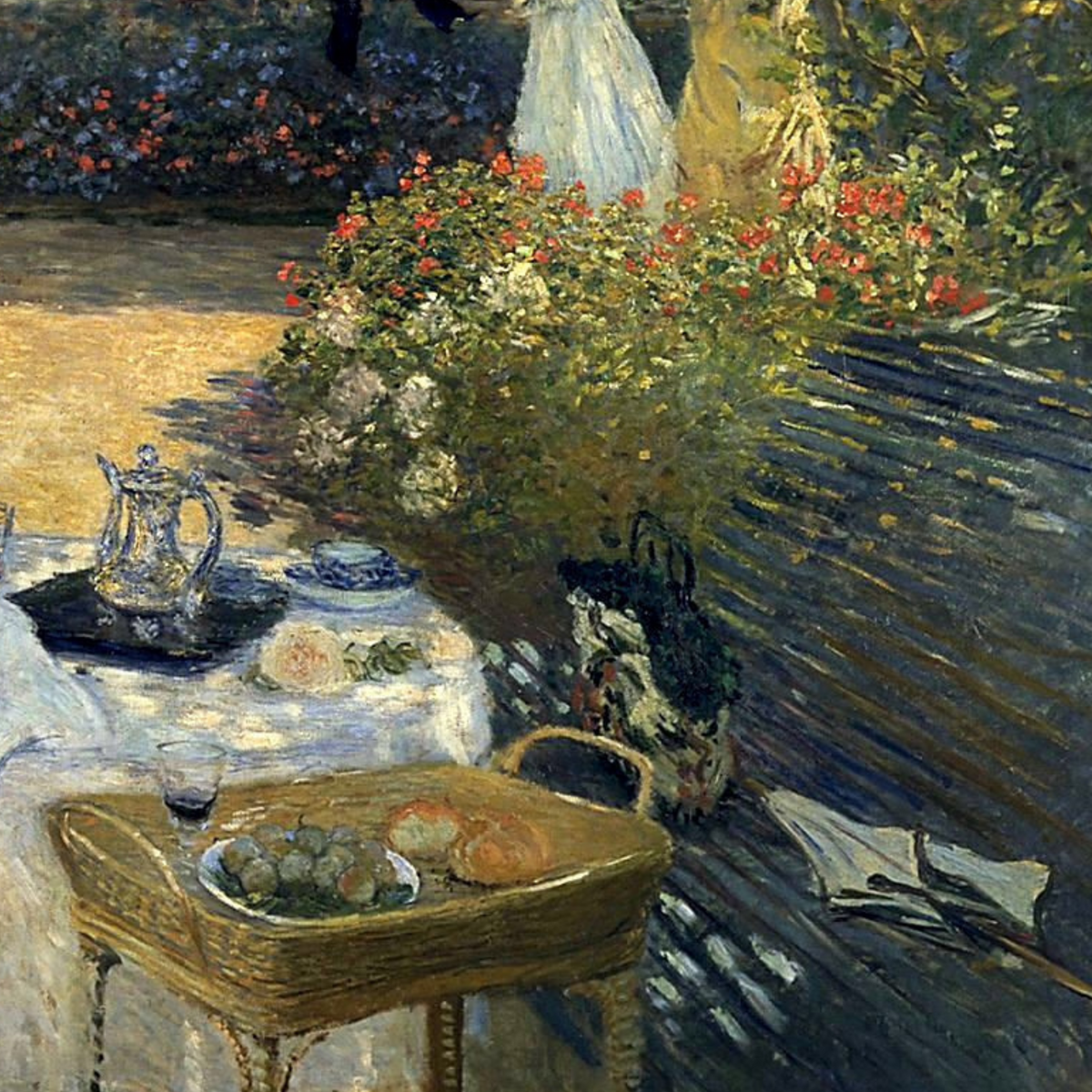 Close-up of flowers, a bench and tableware in dappled sunlight.