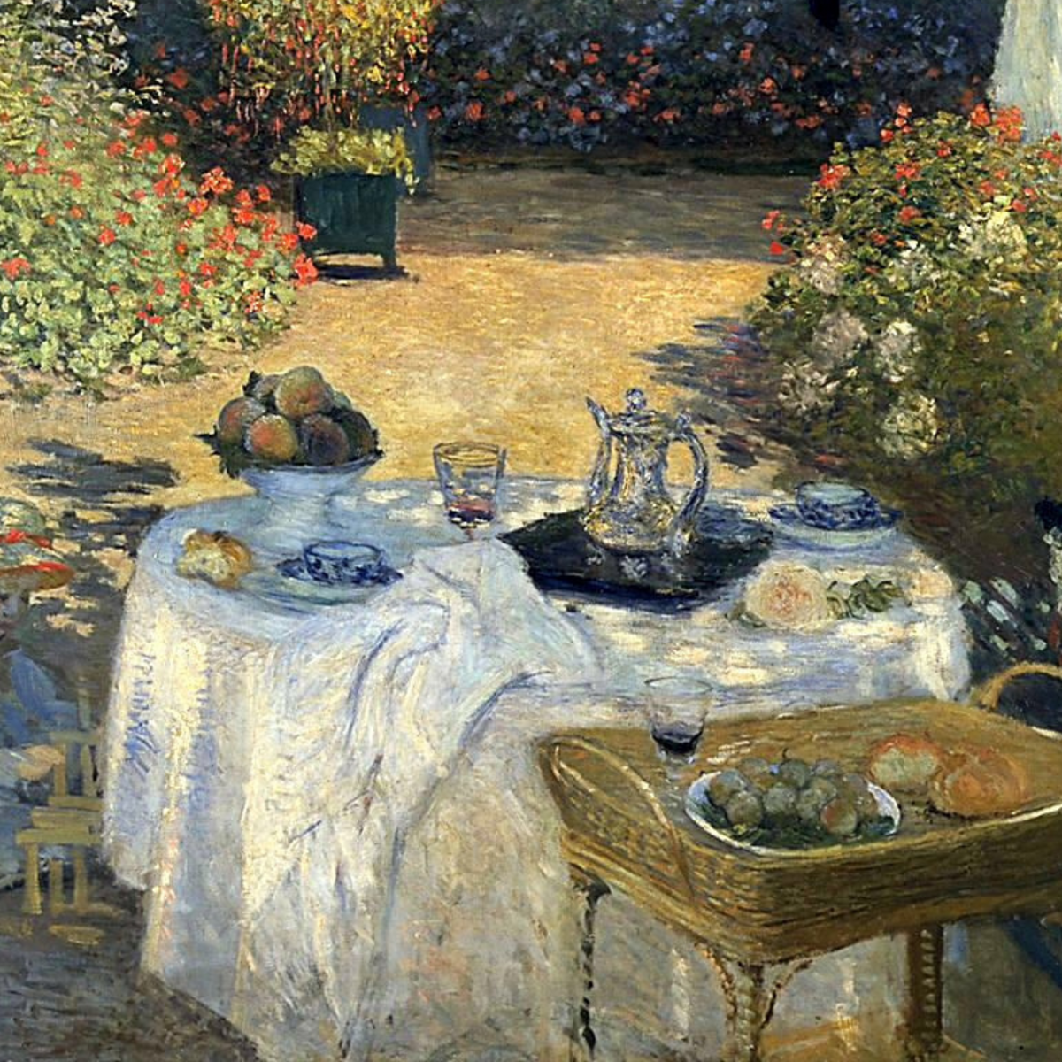 Detail of fruit and dishes on the white garden tablecloth.