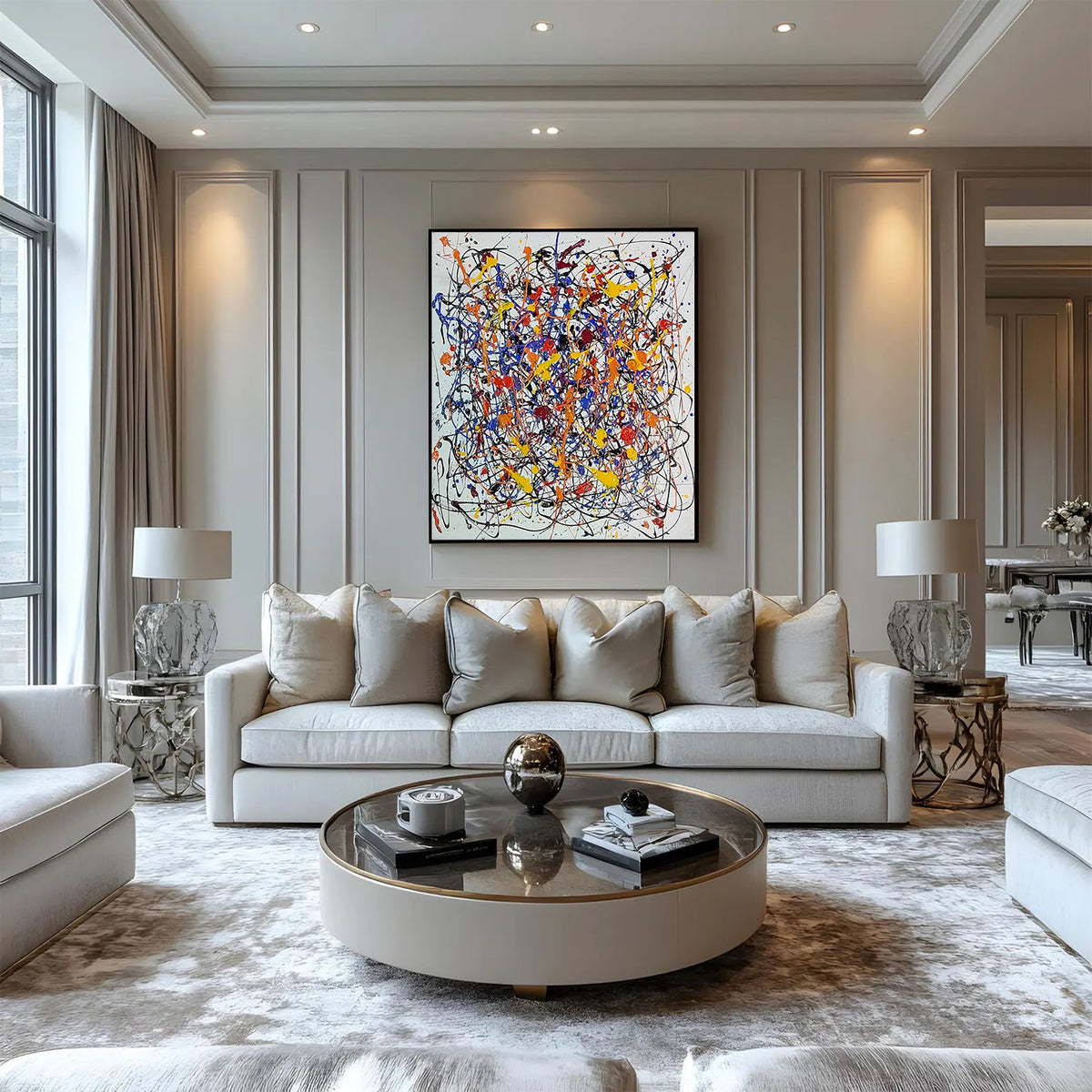 Modern abstract splatter painting mounted on a neutral panelled wall above a cream sofa in an elegant classic living room.