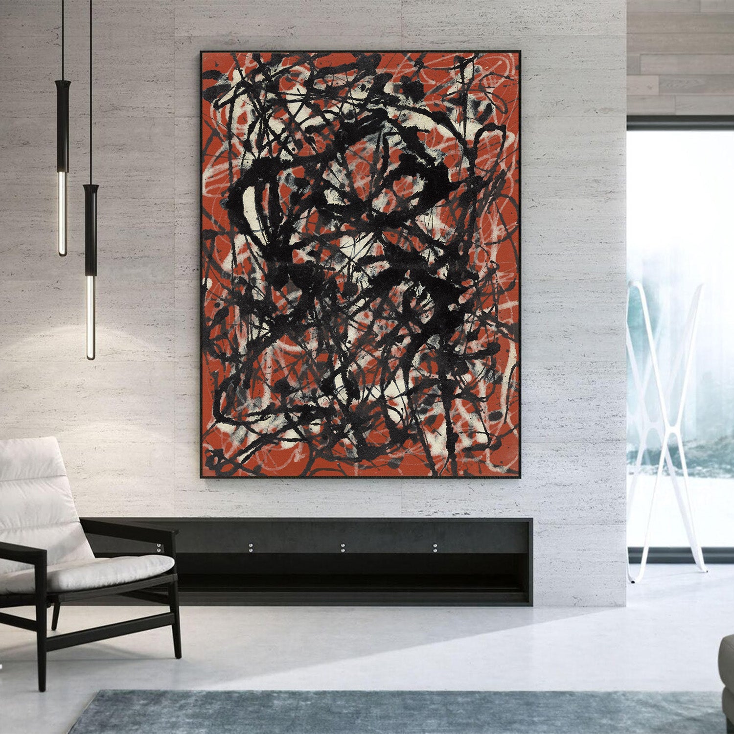 A large abstract canvas print with black and orange-red brushstrokes on a light gray textured wall in a modern living room setting.