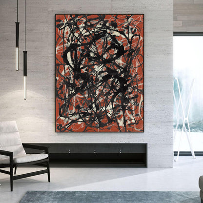 A large abstract canvas print with black and orange-red brushstrokes on a light gray textured wall in a modern living room setting.
