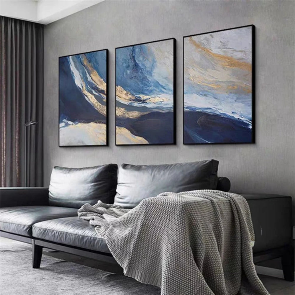 Room mockup showing three abstract panels with deep blue fields, pale blue and cream sweeping bands and gold-coloured accents.