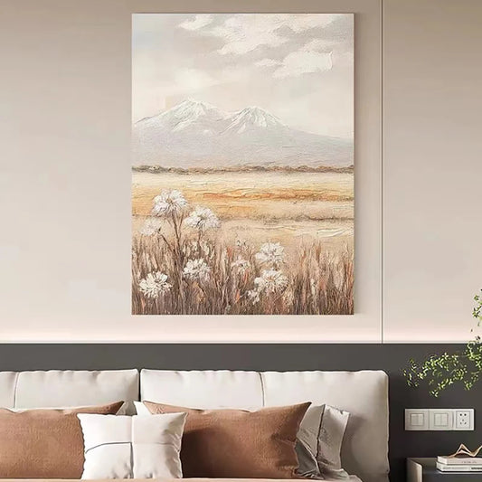 Room mockup showing white wildflowers among brown meadow grasses below distant pale grey mountains and a clouded cream sky.