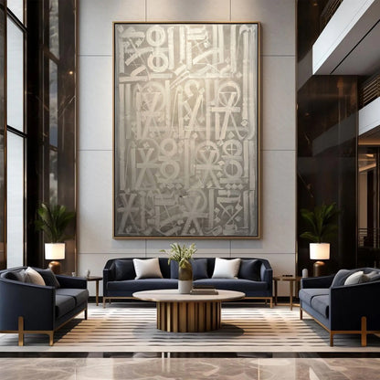 Hand-painted canvas showing symbols, calligraphic marks and geometric forms in neutral tones, displayed in a living room.
