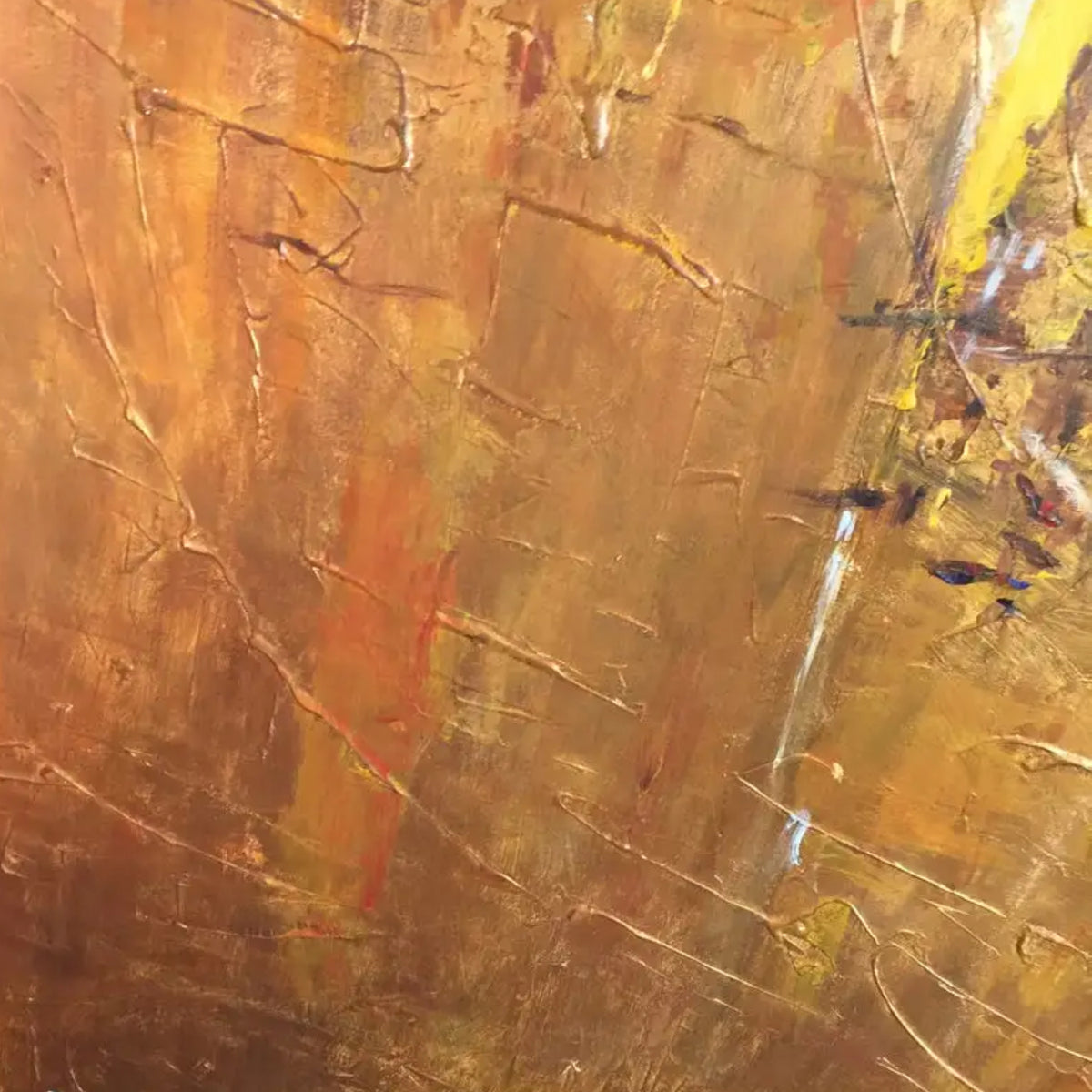 Close-up. A warm ochre and yellow textured field with small green patches, fine dark marks and a narrow white streak.