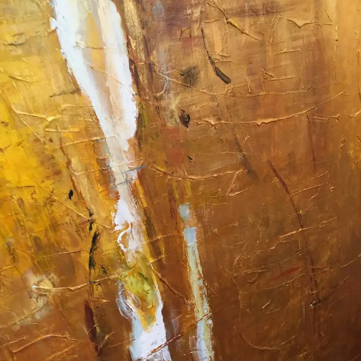 Close-up. A warm ochre and yellow textured field with small green patches, fine dark marks and a narrow white streak.