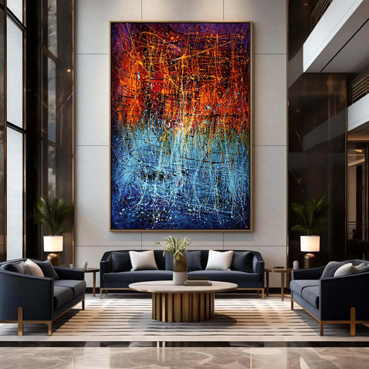 Oversized vertical abstract painting with orange and blue splatter textures displayed in a luxury interior with modern seating.