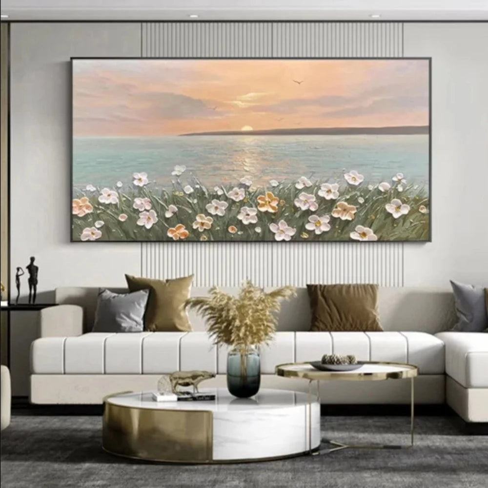 Room mockup showing pink and white flowers on green stems beside calm blue-grey sea beneath a peach sunset and low pale sun.