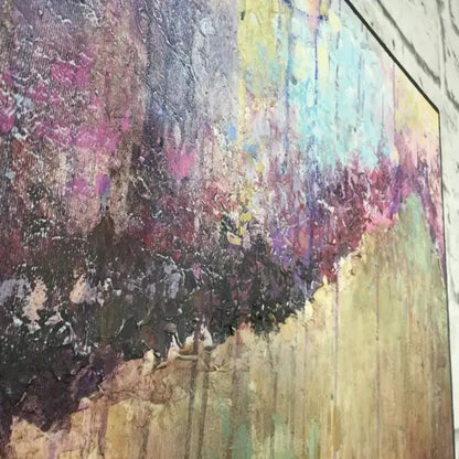 Close-up. A dark purple diagonal band crosses pale blue, pink and green textured areas with fine vertical drips.