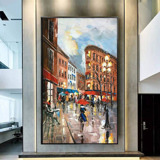 Room mockup. A rainy city square with warm red buildings, streetlamps and figures carrying bright umbrellas on reflective paving.