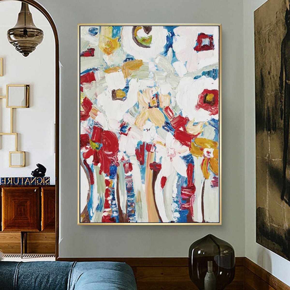 Room mockup. Loose red flower-like patches and blue and ochre stems rise through a heavily textured white background.