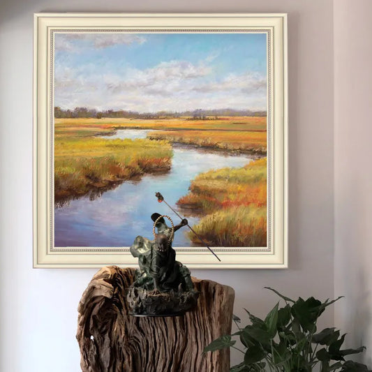 Room mockup. A winding blue stream runs through ochre and green marsh grasses beneath a pale blue sky with soft white clouds.