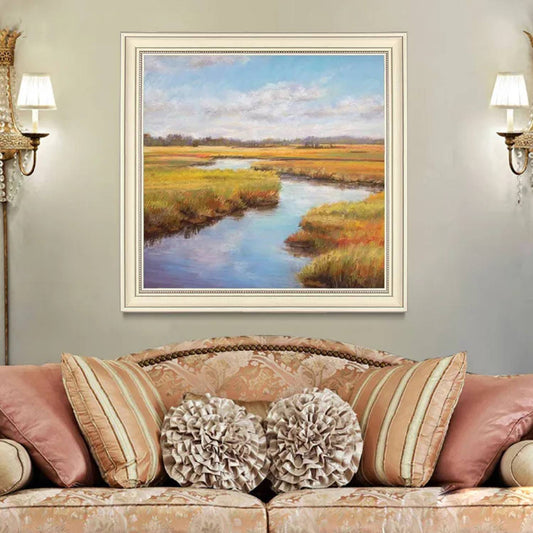 Room mockup. A winding blue stream runs through ochre and green marsh grasses beneath a pale blue sky with soft white clouds.